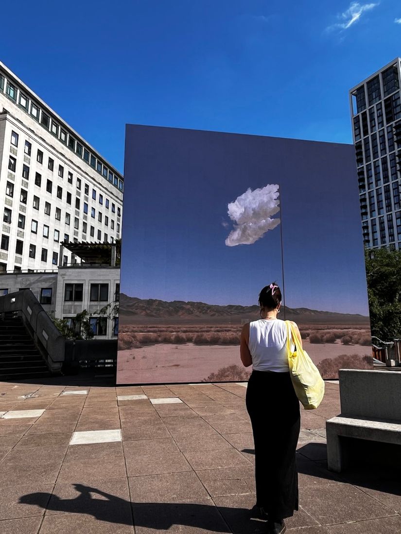 Person vor einer Spiegel-Installation mit Wolke